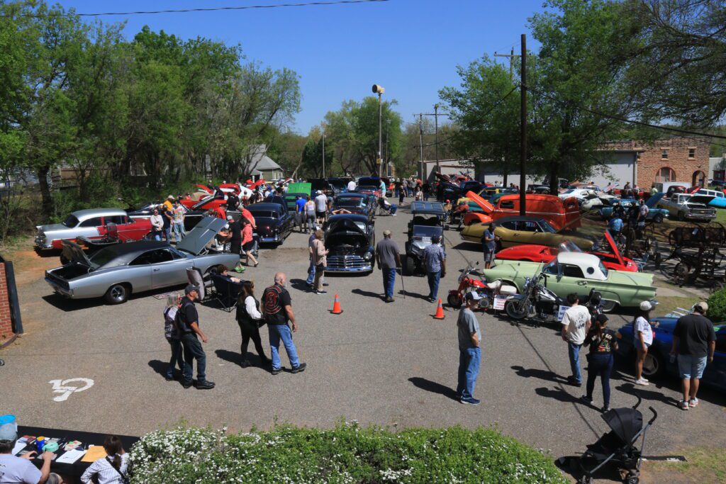 Crowd viewing classic cars, hot rods, and motorcycles at a Route 66 car show in Arcadia, Oklahoma.